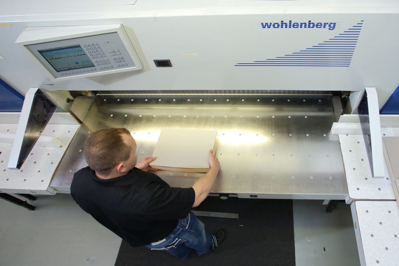 Mitarbeiter von Pütz Folien legt Folienzuschnitte in eine Schneidemaschine ein